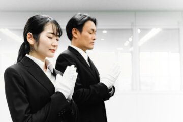 白い手袋をして合掌している男女