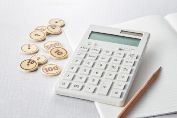 白い電卓とお金を模したチップ