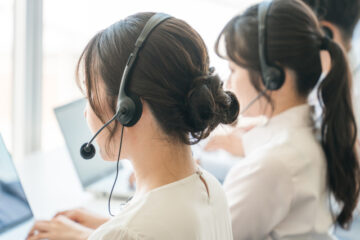 コールセンターで電話対応するオペレーターの日本人女性