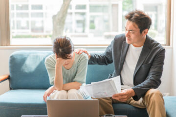 PCの前で頭をかかえている夫婦